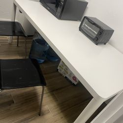 White ikea Table And Two Black Chairs 