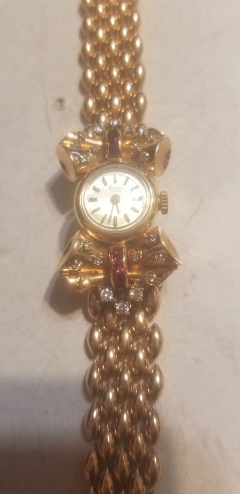 14K gold diamonds and Ruby Geneva Watch The 14K gold ban is attached to the watch work perfectly very good condition use