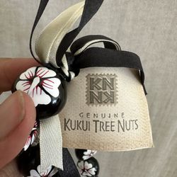  Painted Kukui Nut Choker Lei Necklace, 19 inches. Kukui Nuts are hand painted and laced on a ribbon that ties in the back. Hibisucs flowers are white