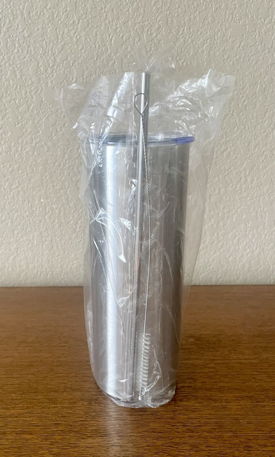 24oz Stainless Steel Tapered Tumbler with a lid, a straw, and a cleaning brush for the straw.