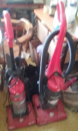2 Dirt Devil vacuum cleaners. 1 has a removable handle with accessories