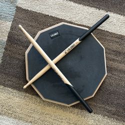 LOLUNUT drum practice pad with drumsticks.