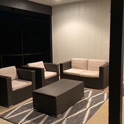 Outside couch and single seats with Cushions and a table