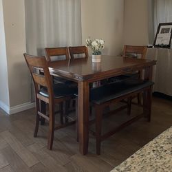 Counter height table with center leaf and four chairs and bench