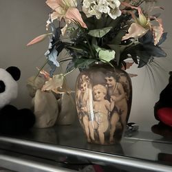Vase with angels decorations and flowers
