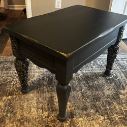 black side table with gold accents.