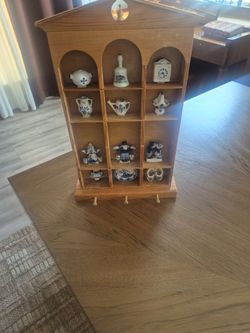 The items in the display case are vintage blue-and-white Delftware-style pottery miniature souvenirs