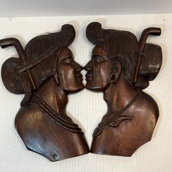 These vintage Filipino hand-carved wood wall plaques depict a couple, often identified as Igorot warriors or people from the Philippines