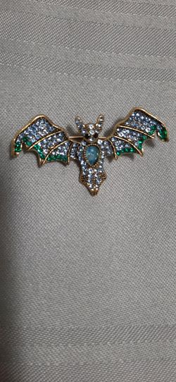 Bat-shaped brooch with Blue & green stones