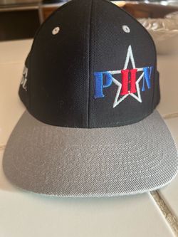 black and gray flat-brim baseball cap featuring an embroidered white, blue, and red star logo with lettering across the front panel
