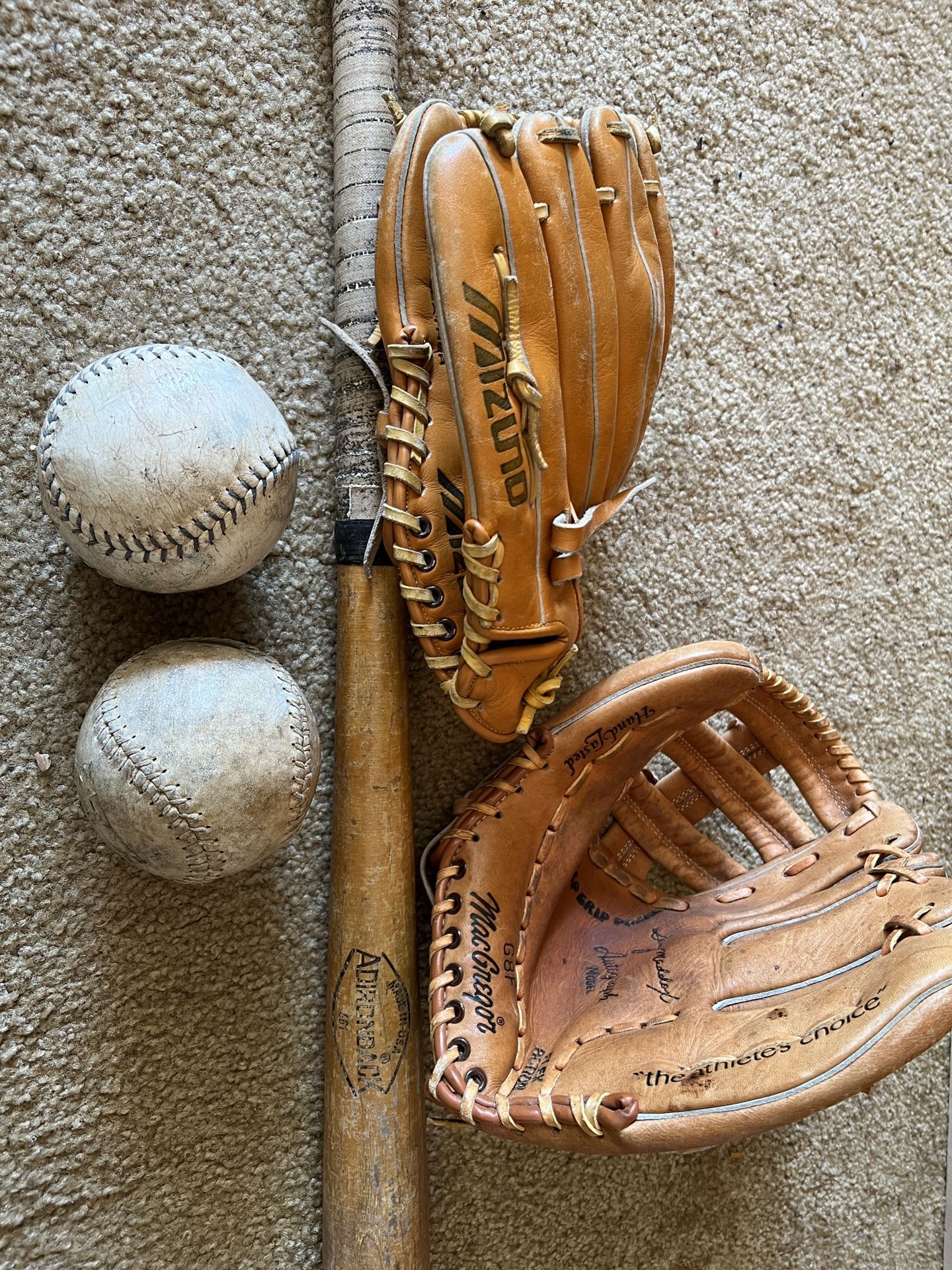 Two Baseball Gloves, Two Softballs And One Baseball Bat