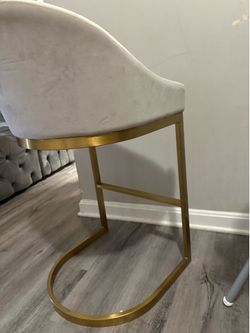 Modern velvet accent/bar chair with a soft cream upholstery and elegant gold metal base