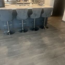 The Sectional And Bar Stools Are Grey 
