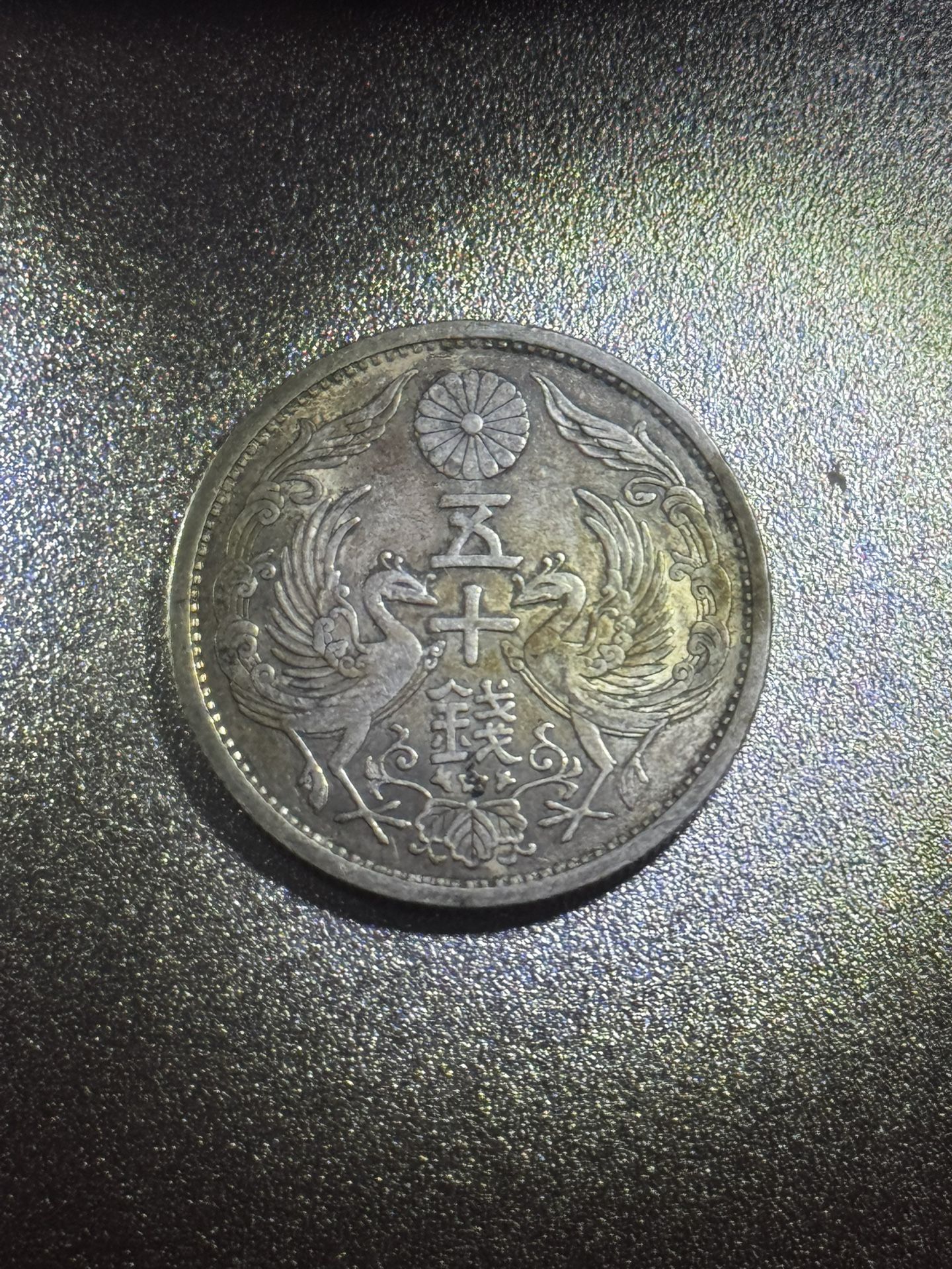 This is a Japanese 50 Sen silver coin.