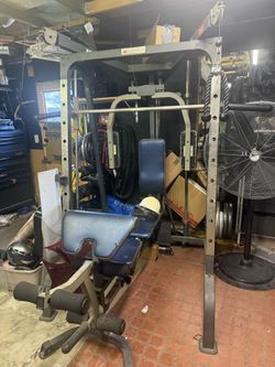 Multi-station Marcy Smith Machine home gym with Olympic bar and weight plates included.