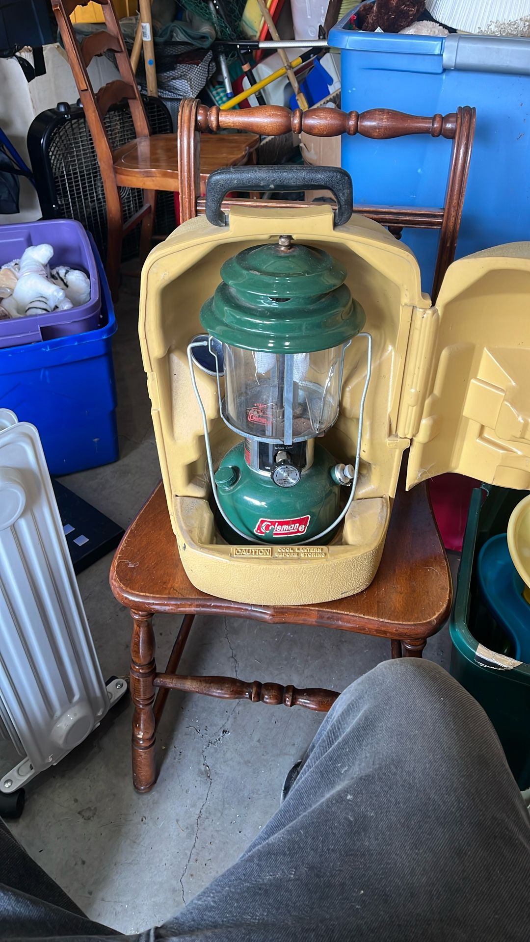 The image shows a vintage Coleman lantern, likely a Model 220 or 228 series, in a yellow plastic clamshell carrying case. These lanterns were produced
