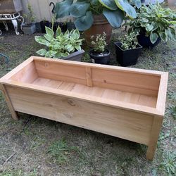  A container made of cedar wood designed for planting flowers & More.