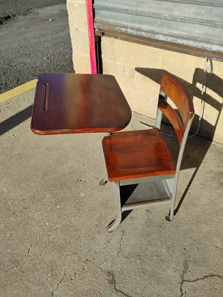 Vintage wood and metal student school desk with an attached right-arm chair and under-seat storage.
