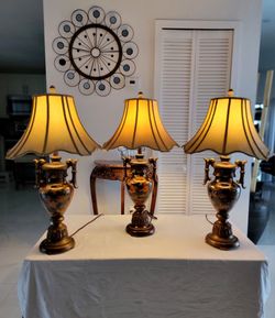 Traditional table lamp from Ashley features an urn-shaped metal base with an antique finish. Price $50 each. D: 19.25" D x 19.25" W x 33.25" H.
