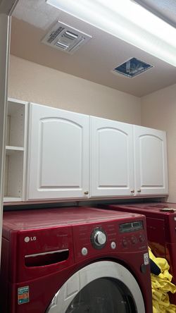 Whit cabinets over laundry washer dryer units