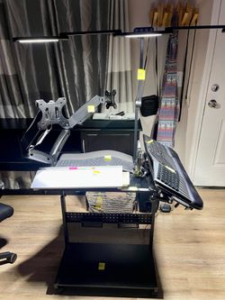 Black Desk Setup with Dual Monitor Arms, Lamps, Keyboards