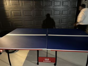 Ping Pong Table, Three Paddles And Several Balls