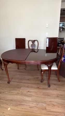 Cherry dining table with six chairs and 2 leafs.