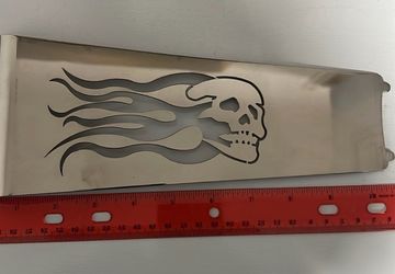 Chrome motorcycle cover accessory with a skull and flame design