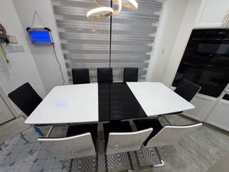 Beautiful modern Italian design dining table with 8 leather chairs in very good condition.