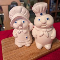 This is a vintage 1988 Pillsbury Poppin' Fresh and Poppie Fresh ceramic salt and pepper shakers set. And A Matching Napkin Holder 