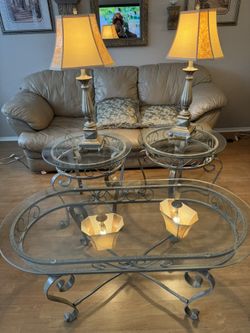 set of wrought iron and glass living room tables, including a coffee table and two end tables, lamps