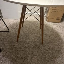 White round table with brown wooden legs (chairs are not included)