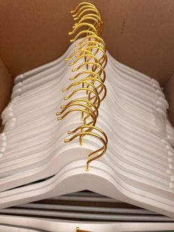 40 brand new white wooden clothes hangers with gold metal hooks.