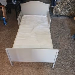 Clean gray toddler bed with mattress