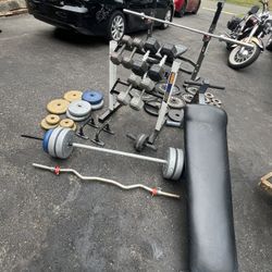 Home gym with decline, benchpress, dumbbells rack, barbell, curl bar, and weight plates
