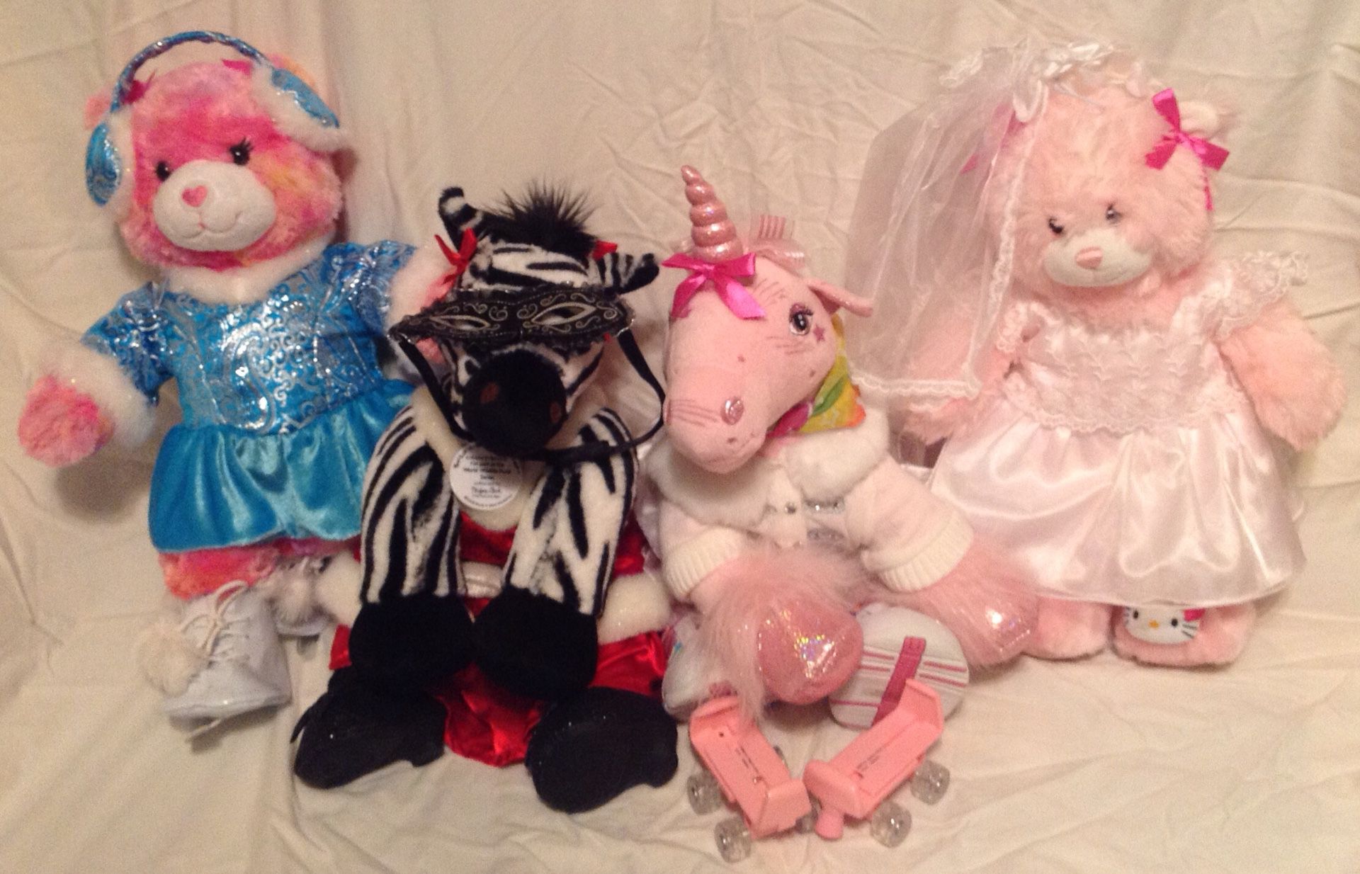 Various BuildaBear plushies with outfits and accessories