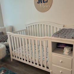 White Baby Crib With Changing Station Attached And Drawers For Storage