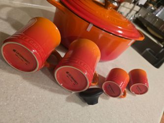 Like new set of Le Creuset big 6-3/4 quart Dutch Oven in Flame with 4 new cups and more items here