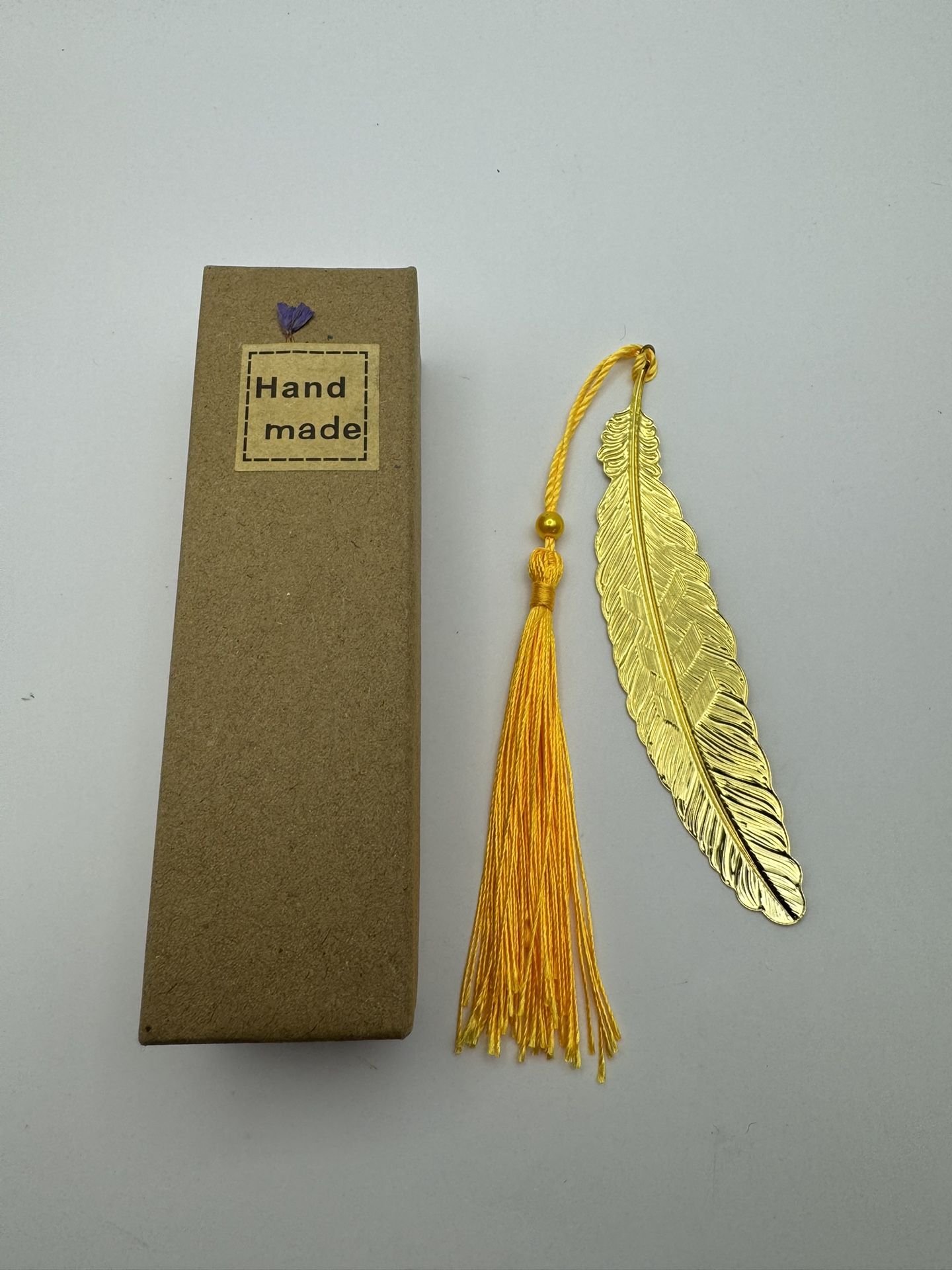 This Handmade Tassel & Metal Feather Bookmark in Gold is the perfect accessory for book lovers. With a length of 4.5 inches and a width of 1 inch, it