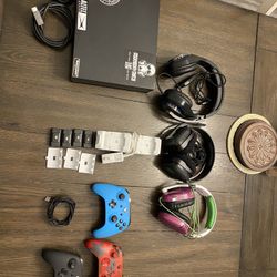Xbox One X with an HDMI cord, 3 controllers, 4 battery packs, a dual battery charger, and 3 headsets