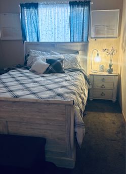 White wash sleigh queen size bed, mattresses, headboard, footboard and frame, wth a matching night stand.