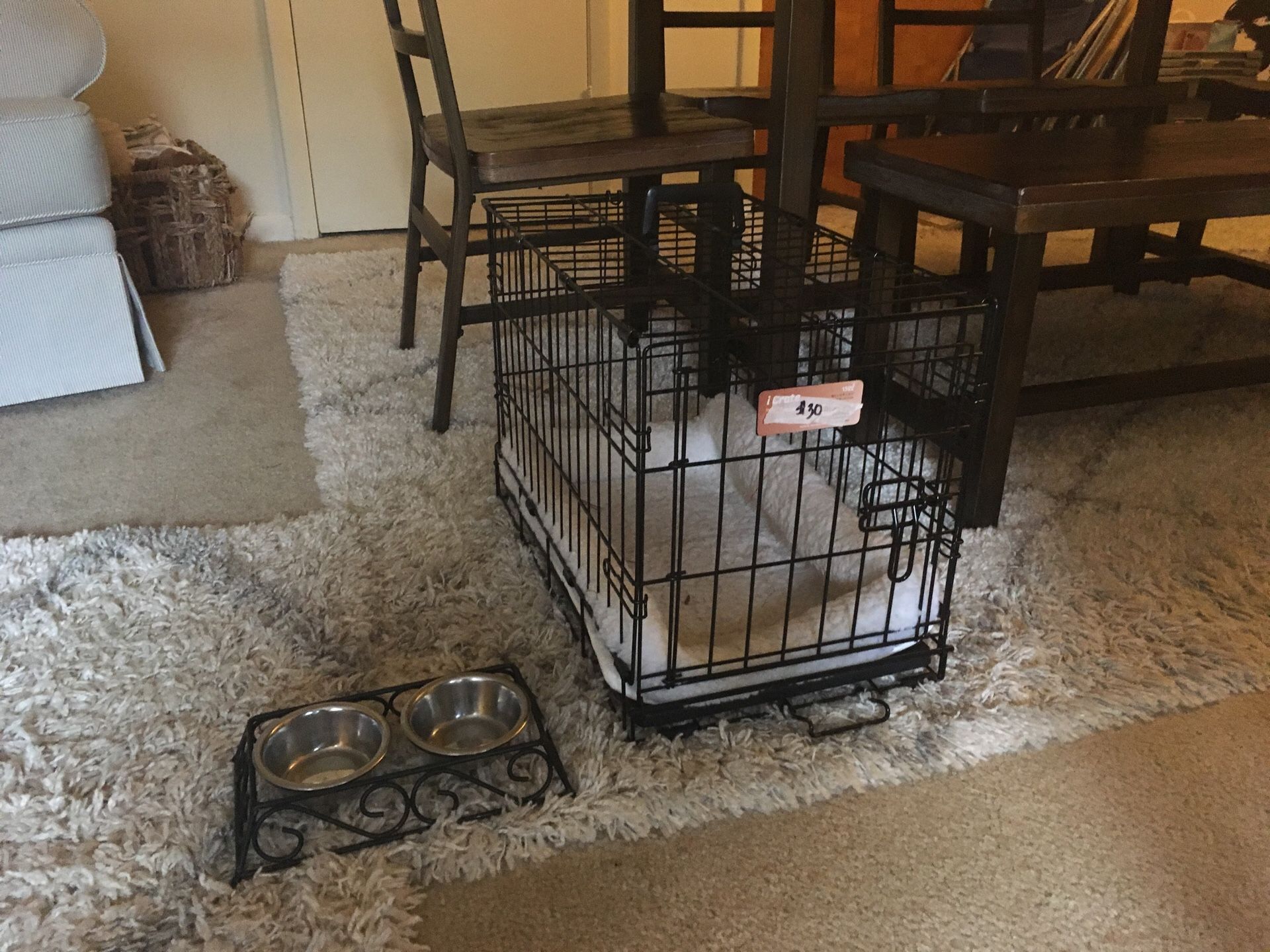 Dog crate with bed and bowls