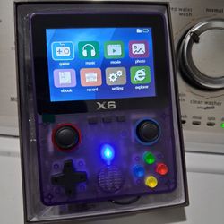 X6 Handheld retro video game console in transparent purple.  New.   fully laminated IPS OCA screen.  Features a dual 3D rocker design 4- core 32 bit p