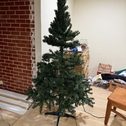 CHRISTMAS TREE, 6'; I half fixed the branches to show what it looks like, LIGHTS DO NOT WORK; cross streets are Arapaho & Waterview