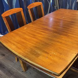 Beautiful convertible two-toned wood dining room table and chairs.