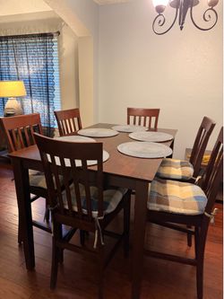 Dining table with chairs and chair cushions and mats