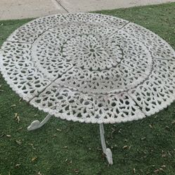 White cast iron patio table.  53 inches round, 27 inches high, 1 1/2 inch opening/hole for umbrella pole. Needs a fresh coat of paint. 