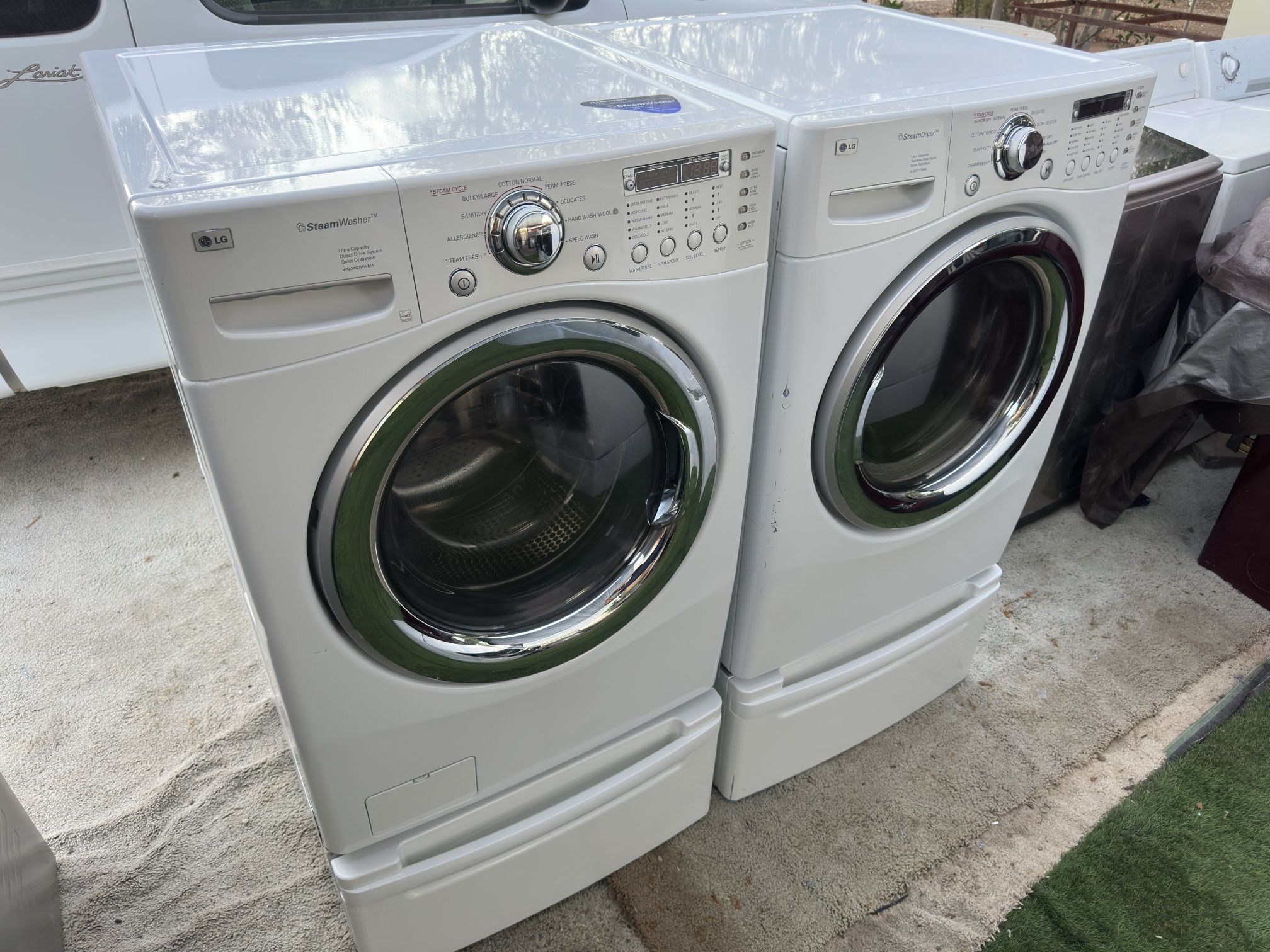 LG washer and electric dryer on pedestals 