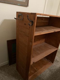 Cowboy boot shelf with horseshoe hooks to hang holster and Carhartt