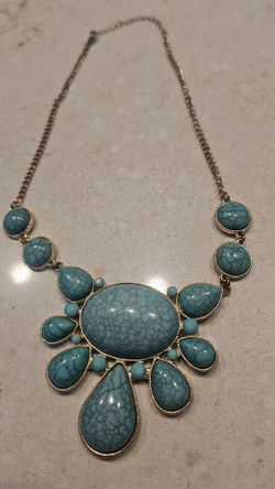 Turquoise colored necklace on gold colored chain.